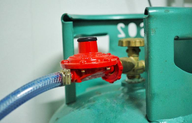Aansluiting van een CO2 waterontharder op een waterleiding. De gascilinder is groen, de kabel blauw en het aansluitstuk rood.